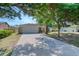 Lovely home featuring an expansive driveway and garage, framed by mature trees and landscaping at 1465 Admrial Nimitz Ave, Daytona Beach, FL 32124
