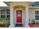 Charming red front door with decorative wreath, flanked by classic columns and lush landscaping at 1465 Admrial Nimitz Ave, Daytona Beach, FL 32124