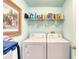 Functional laundry room with modern washer, dryer, and practical shelving for storage at 1465 Admrial Nimitz Ave, Daytona Beach, FL 32124