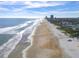 Beach and ocean view shows a bright sunny day with buildings in the far background at 1504 N Atlantic Ave, Daytona Beach, FL 32118