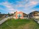 Sprawling backyard with manicured lawn, mature landscaping, a swimming pool and a peek at the neighborhood at 1504 N Atlantic Ave, Daytona Beach, FL 32118