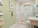 Bright bathroom featuring a walk-in shower with marble-patterned tile and a pedestal sink at 1504 N Atlantic Ave, Daytona Beach, FL 32118