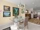 Dining area with tile floors, glass table, wicker chairs and views to a living room with beach views through the windows at 1504 N Atlantic Ave, Daytona Beach, FL 32118