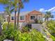 Well-maintained home surrounded by lush greenery with stairs and an elevated patio, offering privacy and charm at 1504 N Atlantic Ave, Daytona Beach, FL 32118