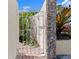 Wrought iron gate framed by stone pillars and lush greenery offers a charming entrance at 1504 N Atlantic Ave, Daytona Beach, FL 32118