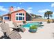 Inviting pool area featuring a screened enclosure, chairs, a spa and a beautifully landscaped deck at 1504 N Atlantic Ave, Daytona Beach, FL 32118