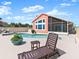 Inviting pool area featuring a screened enclosure, chairs, a spa and a beautifully landscaped deck at 1504 N Atlantic Ave, Daytona Beach, FL 32118