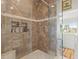 Luxurious glass enclosed shower with tile surround, built-in shelves and dual showerheads at 1504 N Atlantic Ave, Daytona Beach, FL 32118