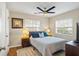 Bright bedroom featuring a ceiling fan, two windows, and hardwood flooring, perfect for relaxation at 1640 Juno Trl # 105D, Astor, FL 32102