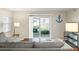 Inviting living area featuring neutral colors, wood-look tile floors, and sliding glass doors to the screened porch at 1640 Juno Trl # 105D, Astor, FL 32102