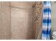 Bathroom with a tiled shower, river rock floor, and a blue striped shower curtain at 1640 Juno Trl # 105D, Astor, FL 32102
