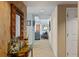 Inviting hallway with decorative mirror and table, neutral colors, and tiled flooring, with living space in the background at 2071 S Atlantic Ave # 1005, Daytona Beach Shores, FL 32118