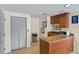 Cozy kitchenette featuring granite countertops, a microwave, a sink, and warm wood cabinetry at 2071 S Atlantic Ave # 1005, Daytona Beach Shores, FL 32118