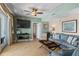 This comfortable living room features tile floors, ceiling fan and a large flat screen television at 2071 S Atlantic Ave # 1005, Daytona Beach Shores, FL 32118