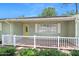 Welcoming front porch featuring a white fence, seating area, and decorative plants, with an inviting front door at 241 Sanchez Ave, Ormond Beach, FL 32174