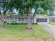 Charming single-story home featuring a well-maintained lawn, mature trees, and a screened garage at 241 Sanchez Ave, Ormond Beach, FL 32174