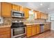 Galley kitchen features oak cabinets, stainless appliances and tiled backsplash at 241 Sanchez Ave, Ormond Beach, FL 32174