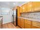 Galley kitchen boasts stainless fridge, plentiful oak cabinets and laminate floors at 241 Sanchez Ave, Ormond Beach, FL 32174