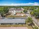 Overhead view of townhomes and the neighborhood with mature trees, tennis court, and sunny skies at 244 Oakleigh Dr # 200, Deland, FL 32724