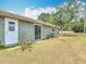 View of the home's side and backyard, featuring a sliding glass door and a small garden at 244 Oakleigh Dr # 200, Deland, FL 32724