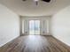 Bright, open living room features vinyl flooring, and sliding glass doors leading to backyard at 244 Oakleigh Dr # 200, Deland, FL 32724