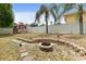 Backyard featuring a shed, fire pit, and lush landscaping, offering a private outdoor space at 2468 Scottville Ave, Deltona, FL 32725