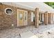 Inviting front porch with brick columns, tile flooring, a bench, decorative rocks and a stylish front door at 2468 Scottville Ave, Deltona, FL 32725