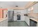 Well-lit kitchen equipped with stainless steel appliances, light countertops and white cabinets at 2468 Scottville Ave, Deltona, FL 32725