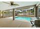 Relaxing screened-in pool area features a ceiling fan, outdoor cooking area, and views of the surrounding backyard at 2468 Scottville Ave, Deltona, FL 32725