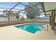 A luxurious screened-in pool features cool water and a backyard with mature landscaping, a brick enclosure, and a privacy fence at 2468 Scottville Ave, Deltona, FL 32725