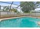 A beautiful screened-in pool features a brick enclosure and a backyard with privacy fence and mature trees at 2468 Scottville Ave, Deltona, FL 32725
