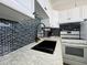 Updated kitchen featuring granite countertops, black tile backsplash, and white cabinetry at 2727 N Atlantic Ave # 602, Daytona Beach, FL 32118