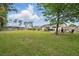 Large backyard featuring a patio with a pool and spa, spacious grassy area, and mature trees at 290 Greenwood Cir, Ormond Beach, FL 32174