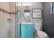 Nicely renovated bathroom with light turquoise vanity, toilet, glass shower stall, and patterned wall tiles at 290 Greenwood Cir, Ormond Beach, FL 32174
