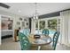 Charming dining area with view of the pool with a unique chandelier and stylish decor at 290 Greenwood Cir, Ormond Beach, FL 32174
