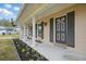 Inviting home exterior featuring a quaint front porch and blooming flower beds at 290 Greenwood Cir, Ormond Beach, FL 32174