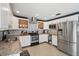 Bright kitchen featuring stainless steel appliances, granite countertops, stylish backsplash, and white cabinetry at 290 Greenwood Cir, Ormond Beach, FL 32174