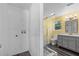 Well lit yellow bathroom with gray wood cabinets, framed mirror, and glass door shower at 342 Euclid Ave, Daytona Beach, FL 32118