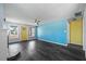 Spacious living room featuring stylish, gray flooring, a sleek ceiling fan, and a bright, yellow door at 342 Euclid Ave, Daytona Beach, FL 32118