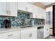 Updated kitchen with white cabinets, mosaic backsplash, and modern fixtures at 3743 S Atlantic Ave # 11D, Daytona Beach Shores, FL 32118