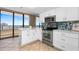 Bright kitchen features white cabinets, stainless steel appliances, and a beautiful backsplash with ocean view at 3743 S Atlantic Ave # 11D, Daytona Beach Shores, FL 32118