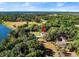 An aerial view shows the expansive property featuring a swimming pool, guest house, and scenic surroundings at 37918 N County Road 44A, Eustis, FL 32736