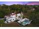 An aerial view shows this home's unique architecture, pool, and its private, lush landscape at 37918 N County Road 44A, Eustis, FL 32736