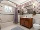 Vintage bathroom design with floral wallpaper, a vanity, and a shower-tub combination at 37918 N County Road 44A, Eustis, FL 32736