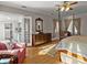 Comfortable bedroom with hardwood floors, four-poster bed, and view to ensuite bathroom at 37918 N County Road 44A, Eustis, FL 32736