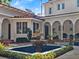 Picturesque courtyard with a tiled fountain, arched columns, and manicured plants at 37918 N County Road 44A, Eustis, FL 32736