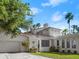 Beautiful exterior of a home with a clay tile roof, a detached garage, and mature landscaping at 37918 N County Road 44A, Eustis, FL 32736