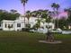 Expansive lawn leads to an elegant, two-story home with a stucco exterior and pristine landscaping at 37918 N County Road 44A, Eustis, FL 32736