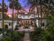 Stunning exterior view showcases a white home with a tile roof, beautiful courtyard, fountain, and intricate landscaping at 37918 N County Road 44A, Eustis, FL 32736