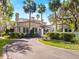 Stately home boasts lush landscaping, a neutral exterior, and a circle driveway at 37918 N County Road 44A, Eustis, FL 32736